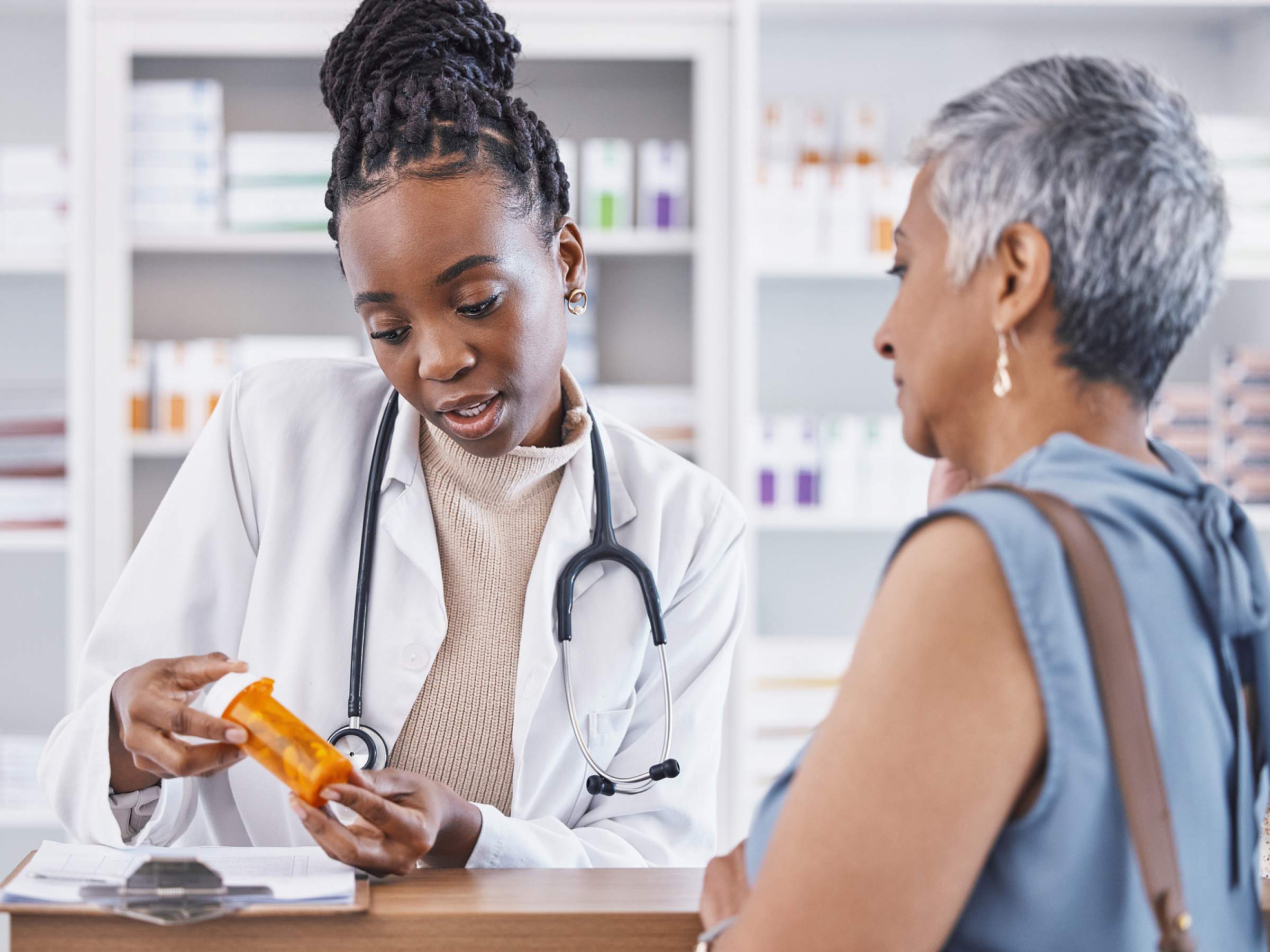 Pharmacist talks to patient at pharmacy