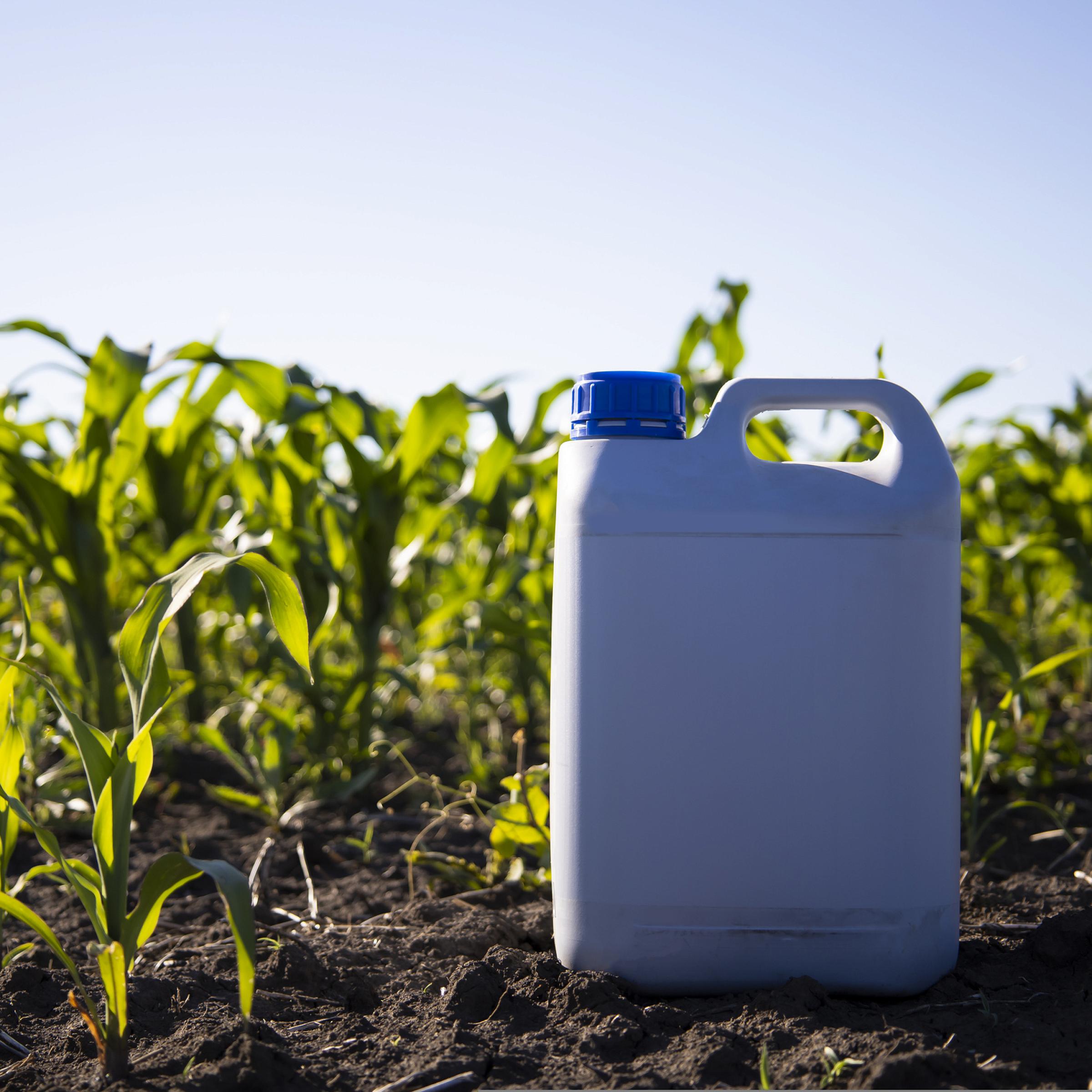 Herbicide bottle in open field